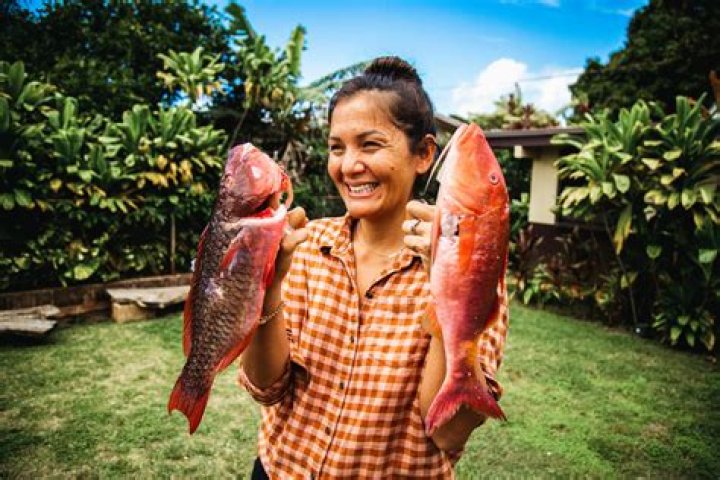 Kimi Werner holding two colorful fish